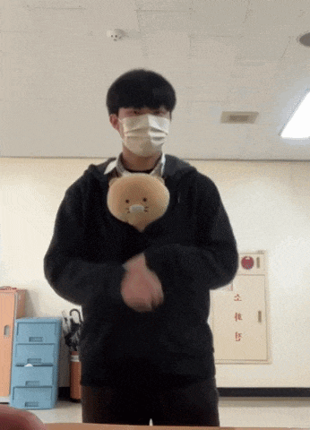 a man wearing a mask holds a stuffed animal