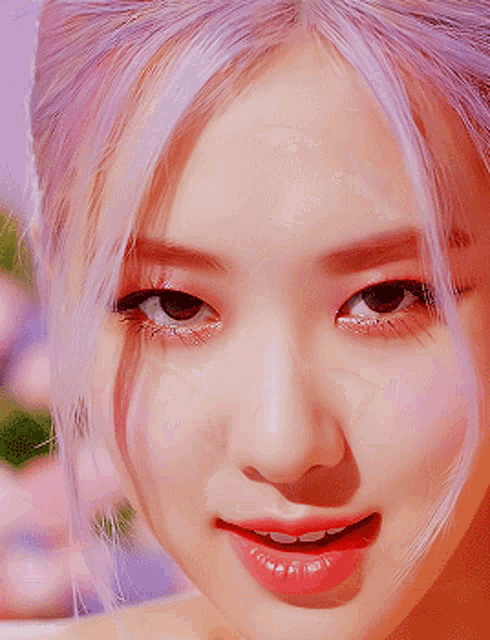 a close up of a woman 's face with pink hair and red lipstick