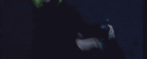 a person with green hair is laying on a blue surface .