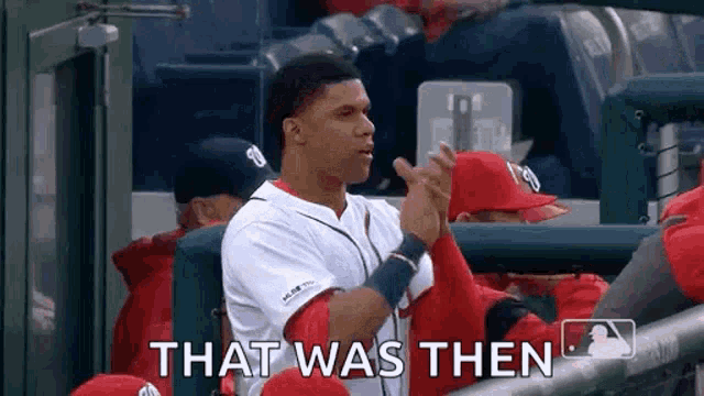 a baseball player is sitting in the dugout clapping his hands and saying `` that was then '' .