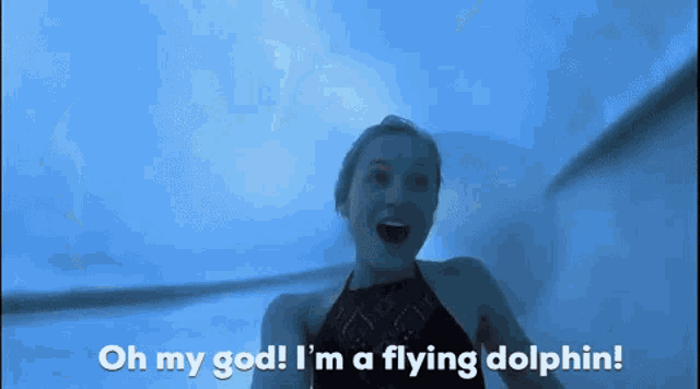 a woman is swimming in a pool with the words oh my god i 'm a flying dolphin