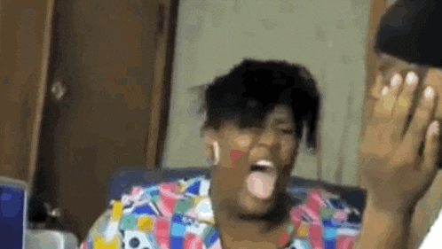 a woman is sitting on a couch with her tongue out .