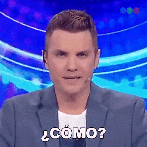 a man in a suit says " como " in front of a microphone