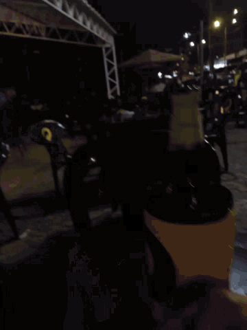 a blurry photo of a crowd of people with a yellow car in the background