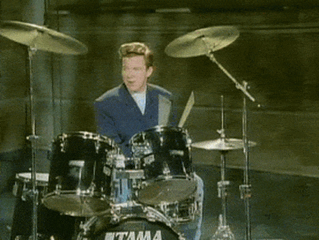 a man in a blue suit is playing a drum set