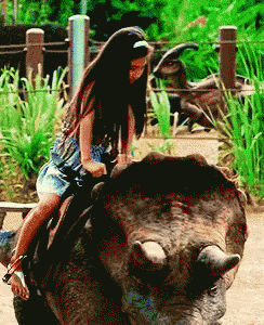 a little girl is riding on the back of a triceratops