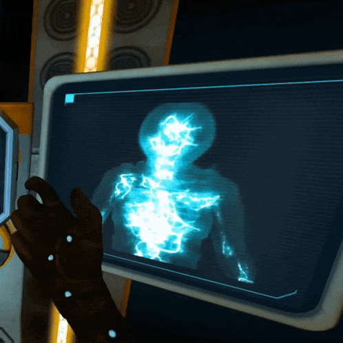 a hand is pointing at a screen that shows a glowing image of a person 's torso
