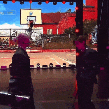 two people are standing in front of a screen that says ' ateez ' on it