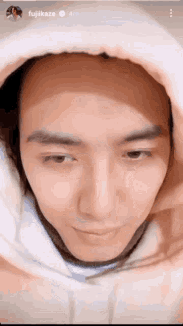 a close up of a man 's face wearing a hoodie