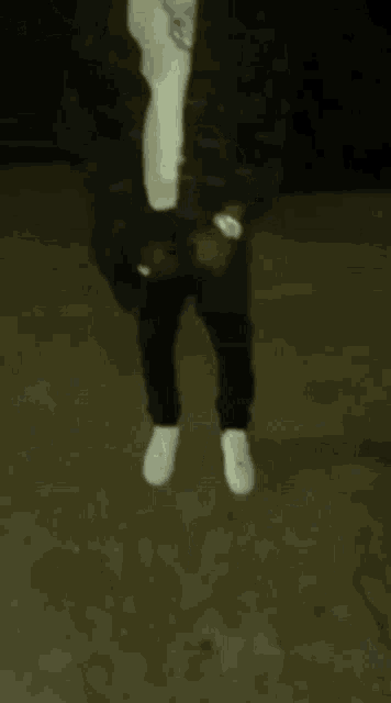 a man in a suit and white socks is standing on a dark floor .