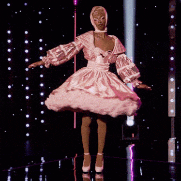 a woman in a pink dress and white heels is dancing