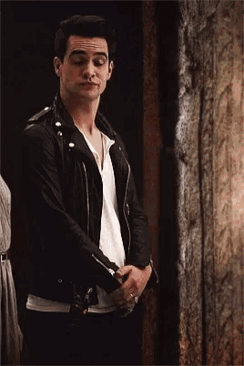 a man wearing a black leather jacket and a white shirt