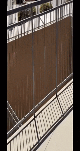 a balcony with a metal railing and a brown screen