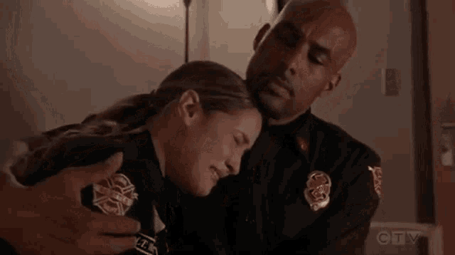 a man and a woman are hugging each other .