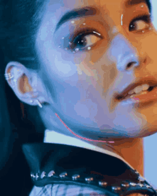 a close up of a woman 's face with a glowing red line on her neck