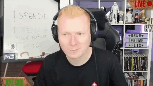 a man wearing headphones stands in front of a white board that says i spende medica