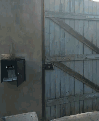 a mailbox with a cup of coffee on top of it next to a wooden fence
