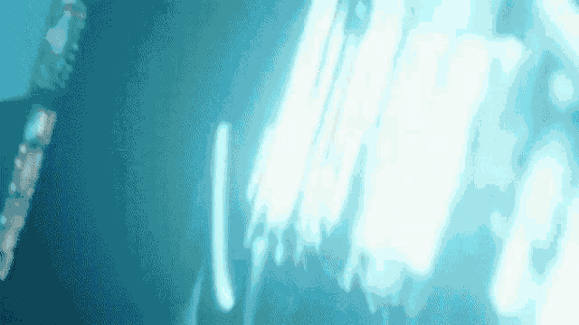 a blurry picture of a person in a dark room with a blue light behind them .
