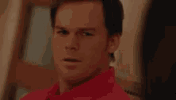 a man in a red shirt is sitting in a chair and saying i 'm so fucking happy for you
