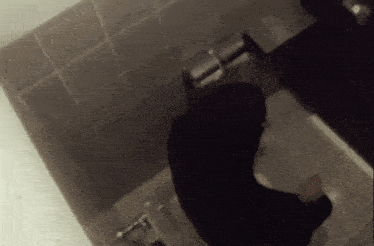a person is sitting on a toilet with their head down