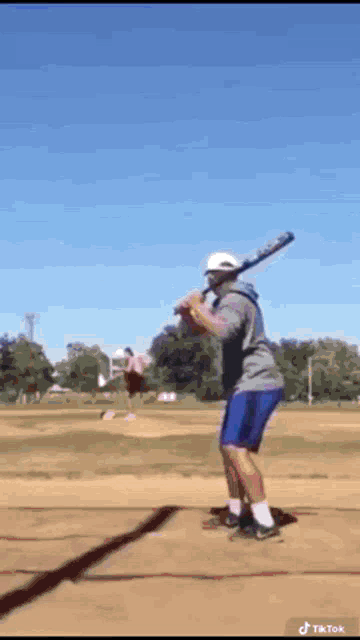 a man is swinging a baseball bat at a ball on a field .