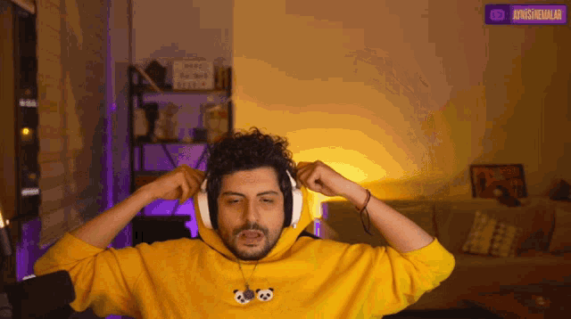 a man wearing a yellow hoodie and headphones has a purple sign above his head that says ' junglemedalar '