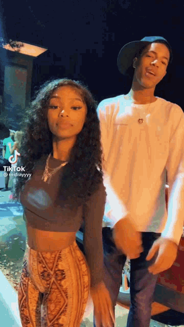 a man and a woman are dancing together at night .