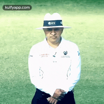 a man wearing a white shirt and a hat with the letters icc on it