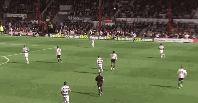 a soccer game is being played on a field with an ad for bet365.com in the background