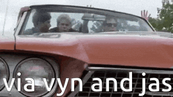 a group of people are sitting in a red car with the words `` via vyn and jas '' written on the front .
