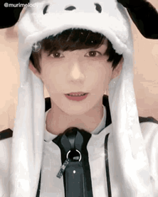 a young man wearing a white hat with ears and a tie