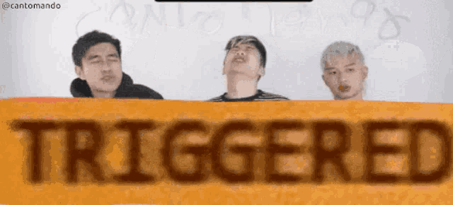 three men behind a sign that says " triggered "