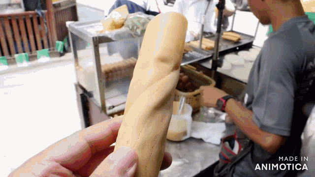 a person is holding a sandwich in their hand with the words made in animotica below it