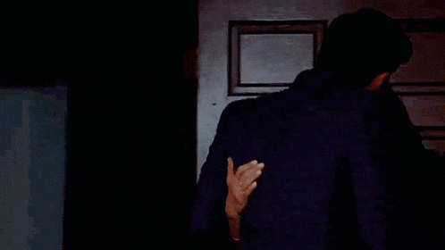 a man and a woman kissing in front of a door .