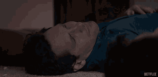 a man laying on the floor with a netflix logo in the lower right corner