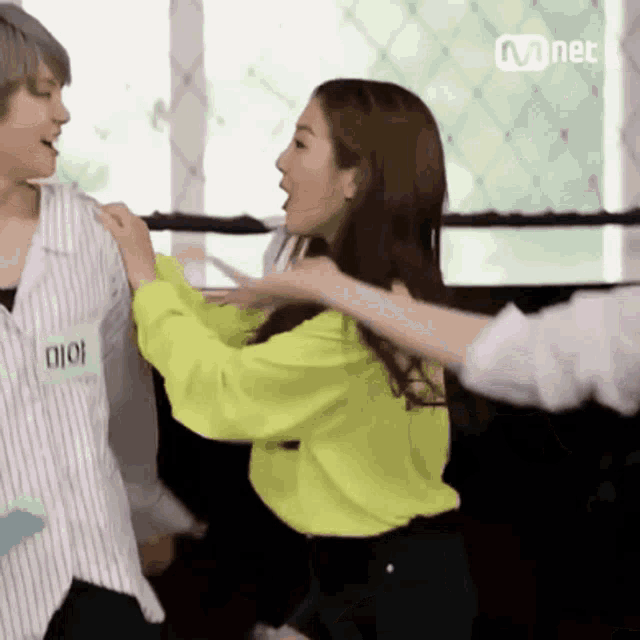 a woman in a neon green shirt is hugging another woman