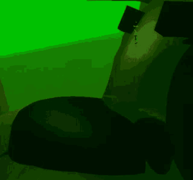 a green background with a black object in the middle