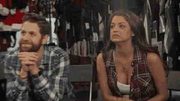 a man and a woman are sitting next to each other in a room .