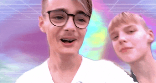 a man wearing glasses is standing next to a woman wearing a white shirt