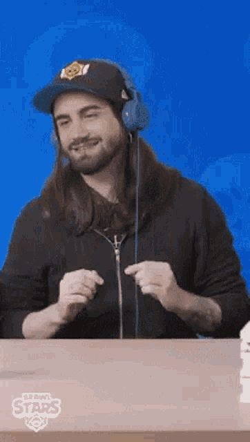 a man with long hair is wearing headphones and a hat with a pumpkin on it
