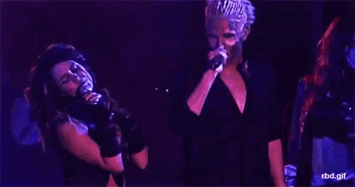 a man and a woman are singing into microphones on stage .