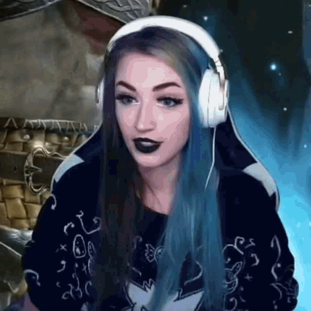 a woman with blue hair wearing headphones and black lipstick