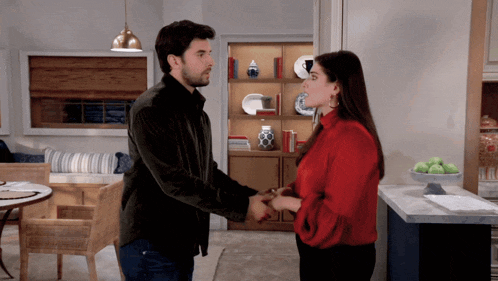 a man and a woman are holding hands in a living room