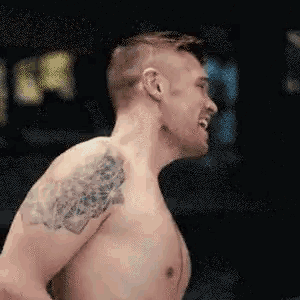 a man without a shirt has a tattoo on his shoulder