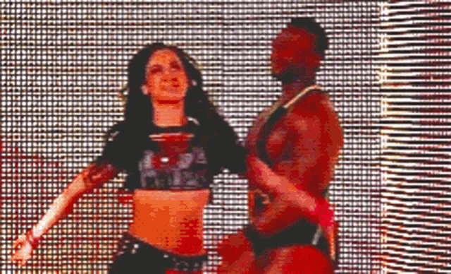 a man and a woman are dancing in front of a screen .