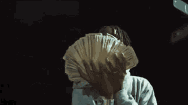 a man is holding a stack of money in his hands that says 100