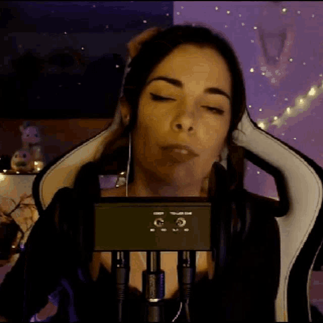 a woman is sitting in a chair with headphones on her head .
