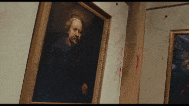 a painting of a man in a gold frame hangs on a wall with blood on it
