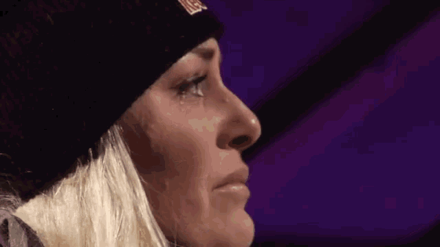 a close up of a woman wearing a black beanie with a uss logo on it