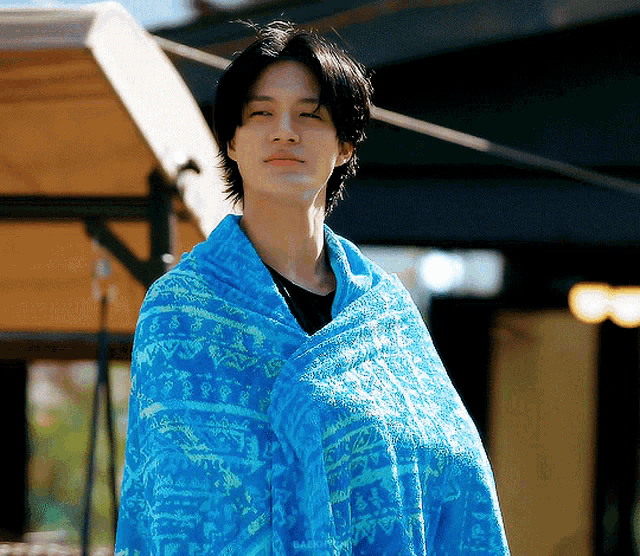 a young man is wrapped in a blue and yellow towel